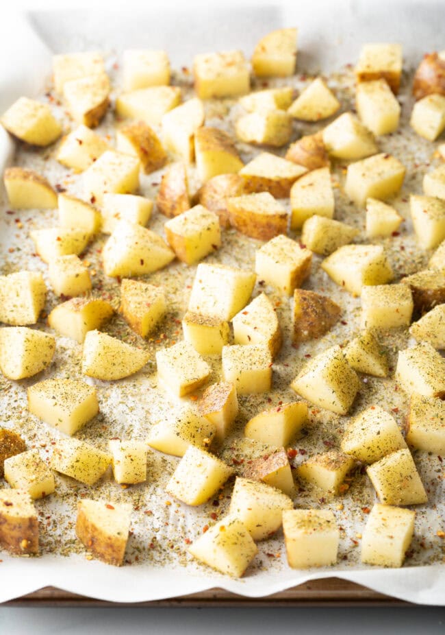 Raw cubes seasoned on parchment.