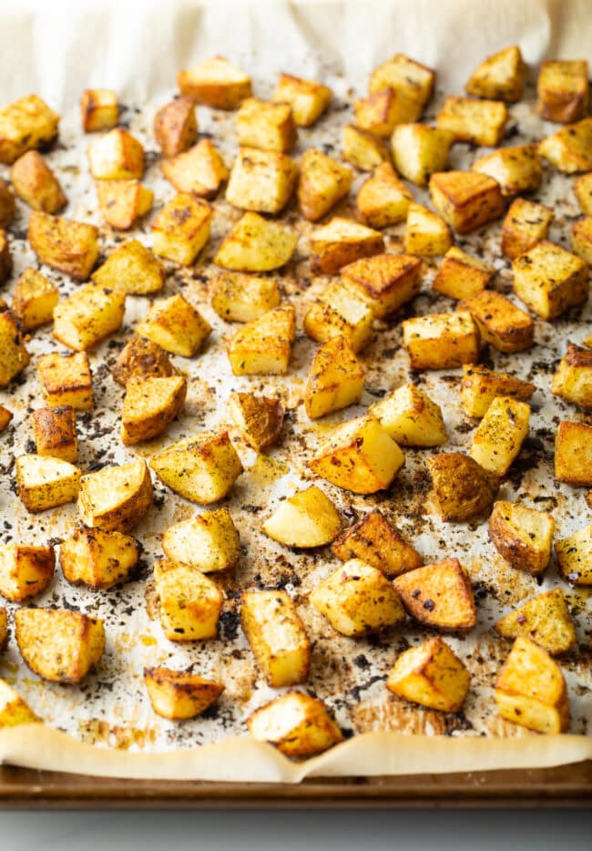 Chopped baked russet potatoes on a baking sheet.