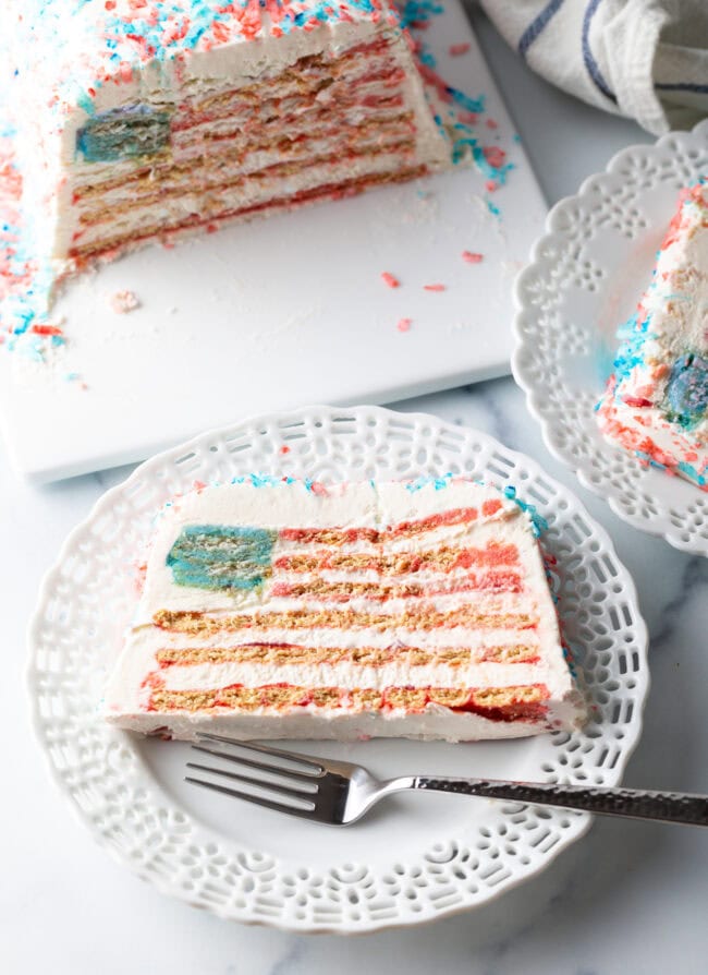 Top down view of a slice of American flag cake on a white plate, with fork.