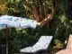 fringed retro style umbrella and floral cushions with pom pom fringe near backyard pool