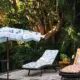 fringed retro style umbrella and floral cushions with pom pom fringe near backyard pool