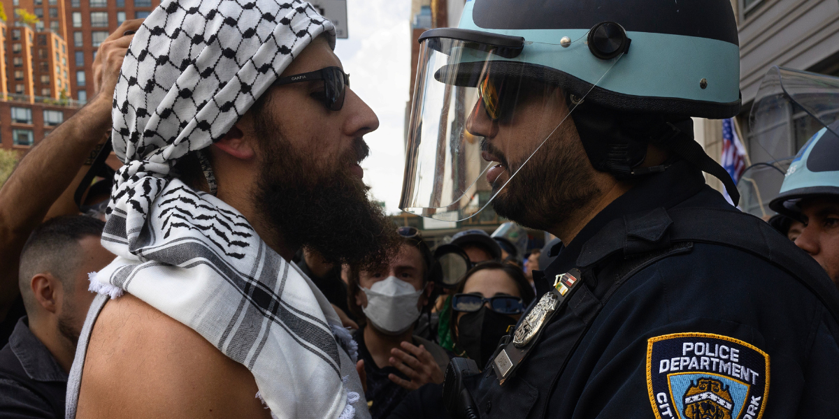 a pro Palestine activist faces off with a cop