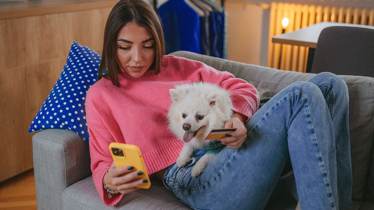 A beautiful young woman is shopping online using a mobile phone