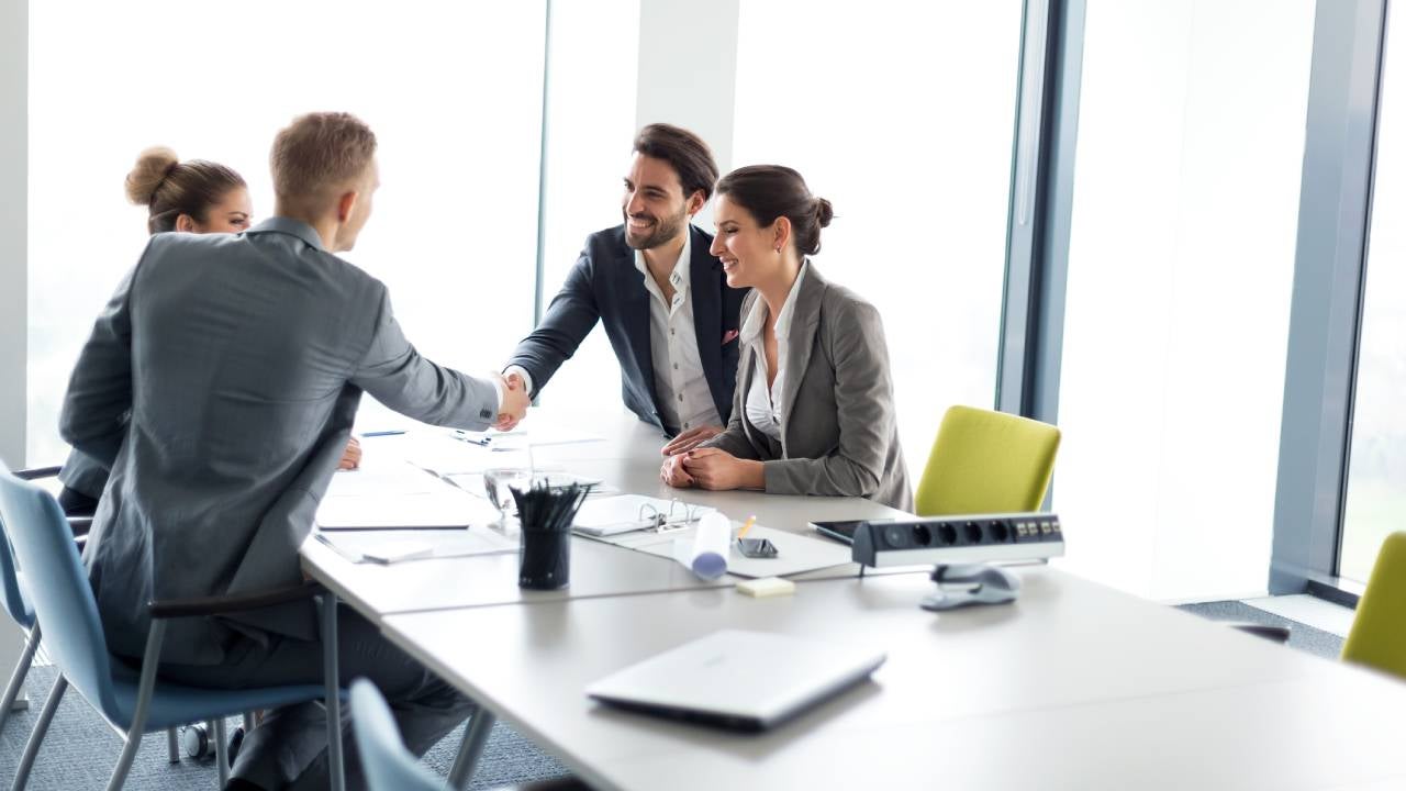 Happy couple meeting their financial advisor, shaking hands