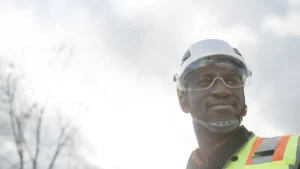 construction worker with the sunlight & sky behind him