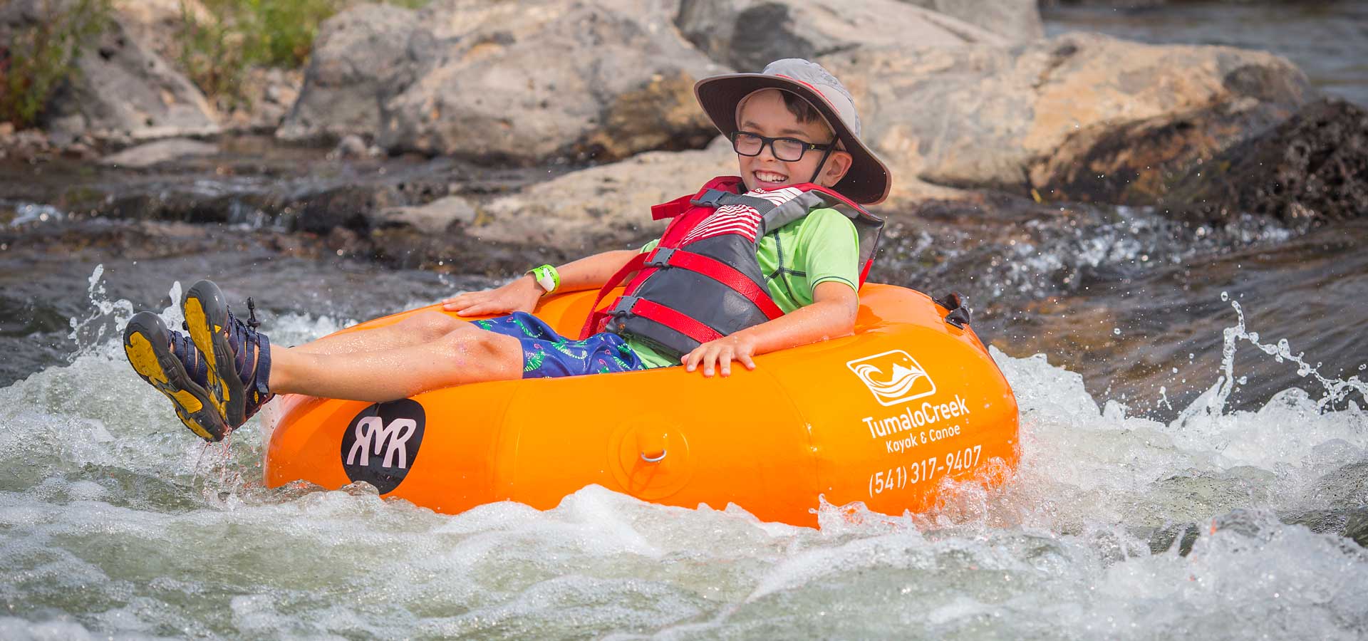 Boy on tube floating through rapids