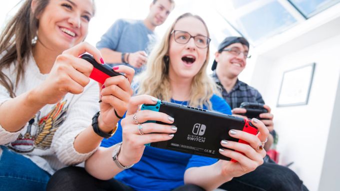 Portrait of a group of men and women playing video games on a Nintendo Switch console with Nintendo Pro and Joy Con wireless controllers, taken on March 7, 2017. (Photo by James Sheppard/Future via Getty Images)