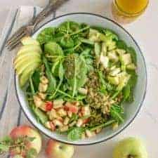 Bowl of spinach salad with apples and apple vinaigrette