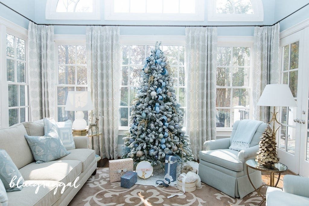 blue christmas decorating ideas with a white flocked tree in a sun room with blue wall paint