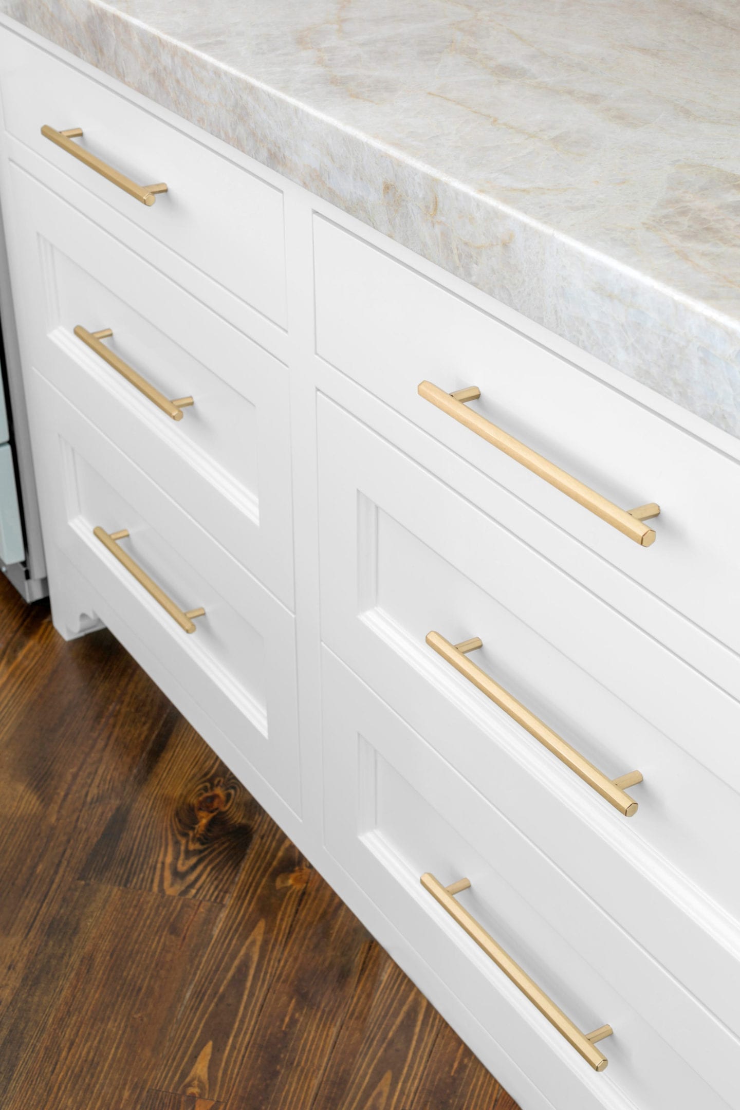 Gold Cabinet Hardware from Vesta on white cabinets with Taj Majal Quartzite countertops.