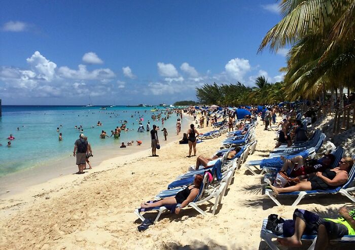 a lot of people lying on loungers or swimming in the sea