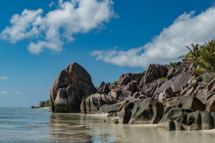 big dark grey rocks in the water on the shore