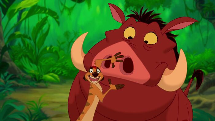 Iconic best friend duo from an animated film, featuring a meerkat and a warthog in a lush jungle setting.