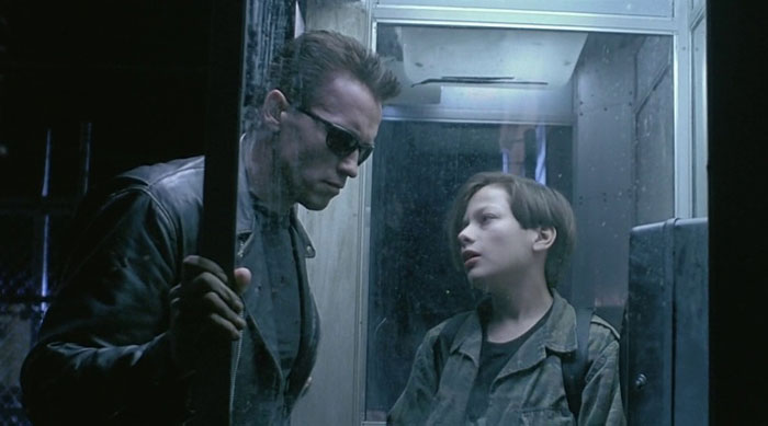 Two iconic characters standing in a phone booth, one wearing sunglasses, representing a classic best friend duo.