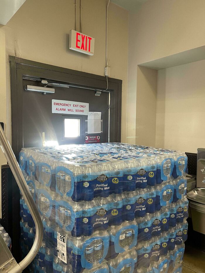 Stack of water bottles blocking an emergency exit, illustrating lazy-infuriating-people behavior.