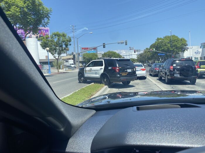 Police SUV parked on sidewalk, causing inconvenience to other drivers, exemplifying lazy-infuriating behavior.