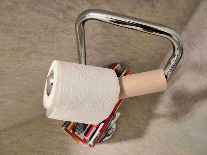 Toilet paper roll stacked lazily on cardboard tube by lazy-infuriating-people, resting on a metal holder.