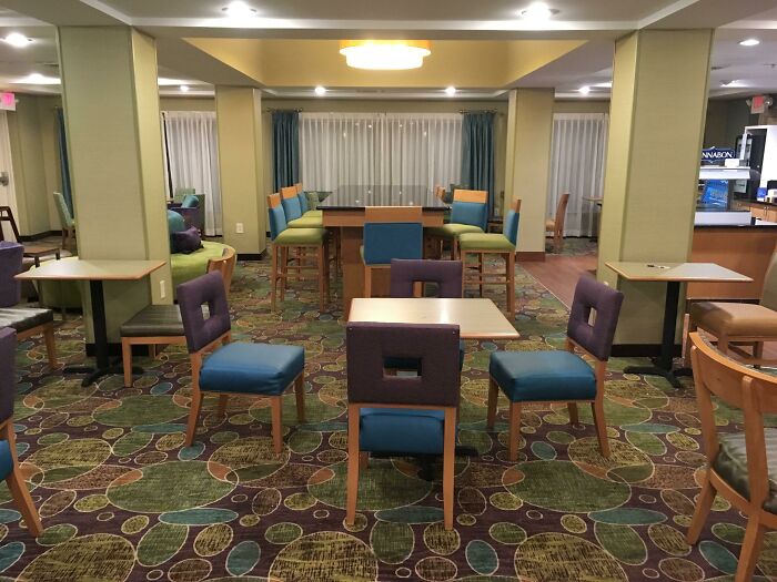 Empty hotel lounge with colorful chairs scattered randomly, highlighting lazy-infuriating-people behavior.