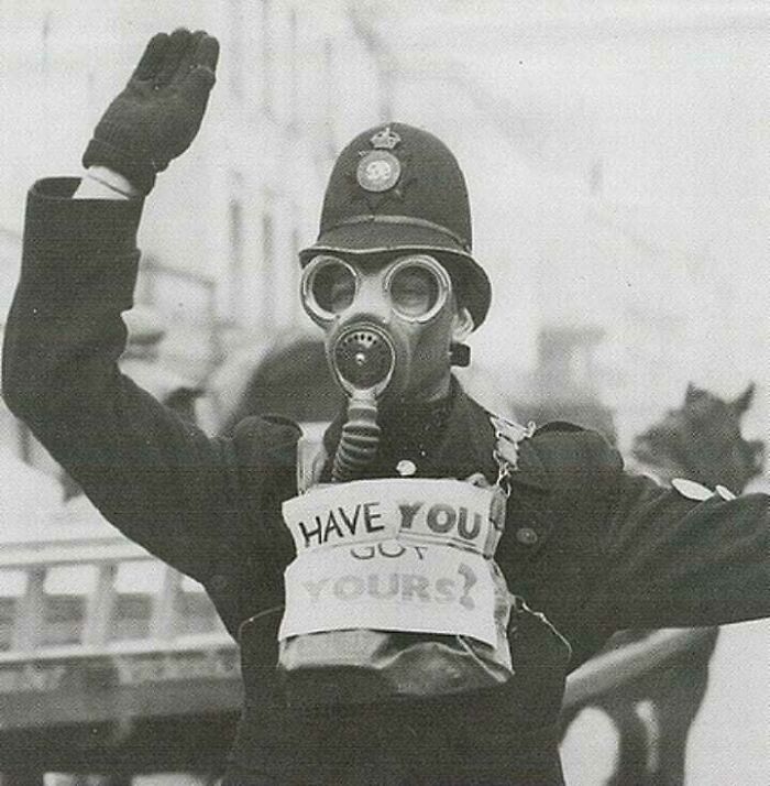 Vintage photo of a historical police officer wearing a gas mask with a sign saying "Have You Got Yours?"