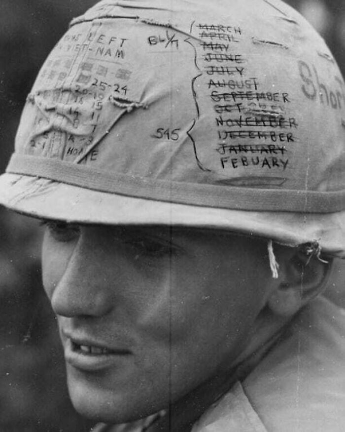 Soldier wearing a helmet with hand-drawn calendar, representing historical memory and wartime reflections.