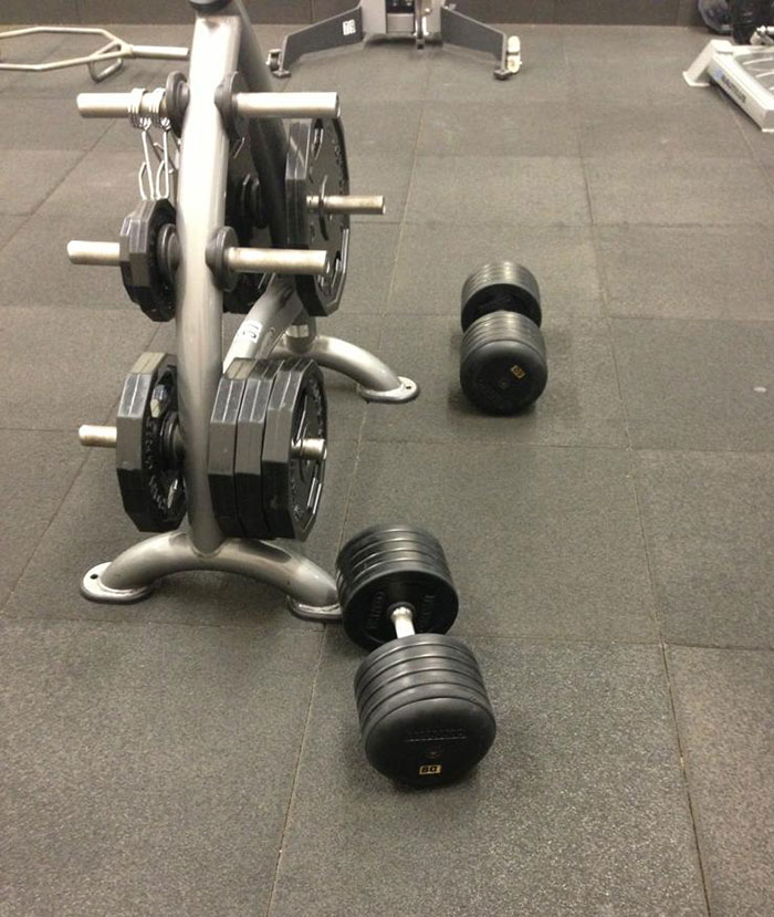 Dumbbells left on gym floor by lazy people, not placed back on rack.