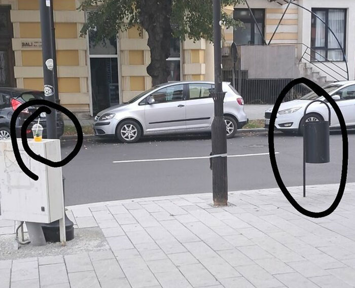 Cup left on a utility box near the street, trash can in the distance, illustrating lazy-infuriating-people behavior.