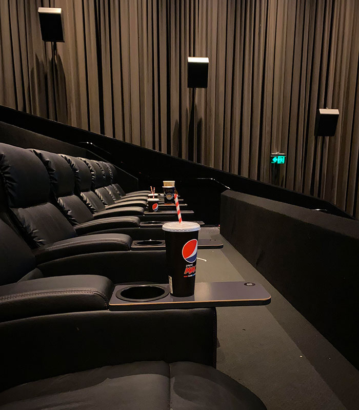 Empty movie theater seats with scattered trash, illustrating lazy, infuriating behavior.