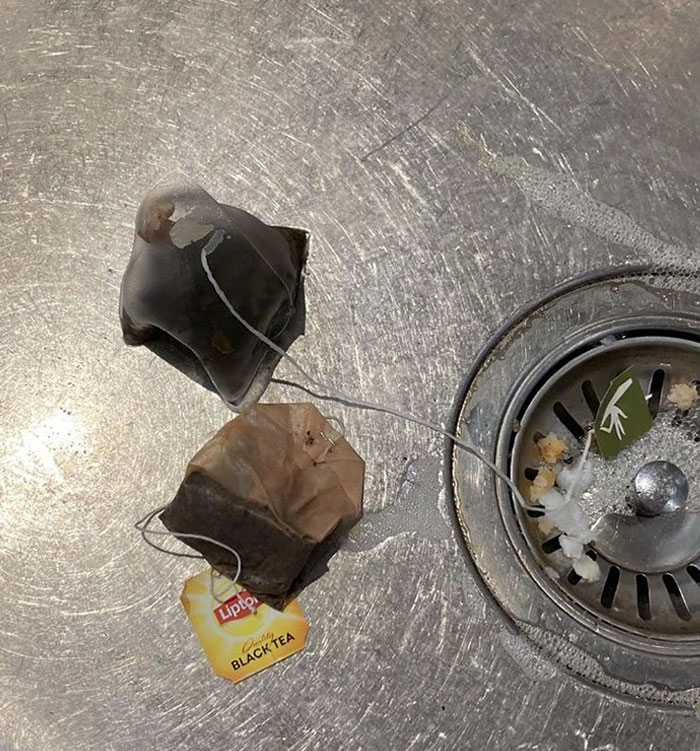 Abandoned tea bags on a stainless steel sink, epitomizing lazy-infuriating-people behaviors.