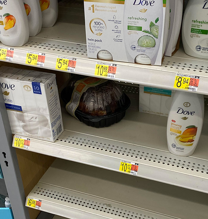 Rotisserie chicken misplaced on a store shelf among soap bottles as an example of lazy-infuriating-people behavior.