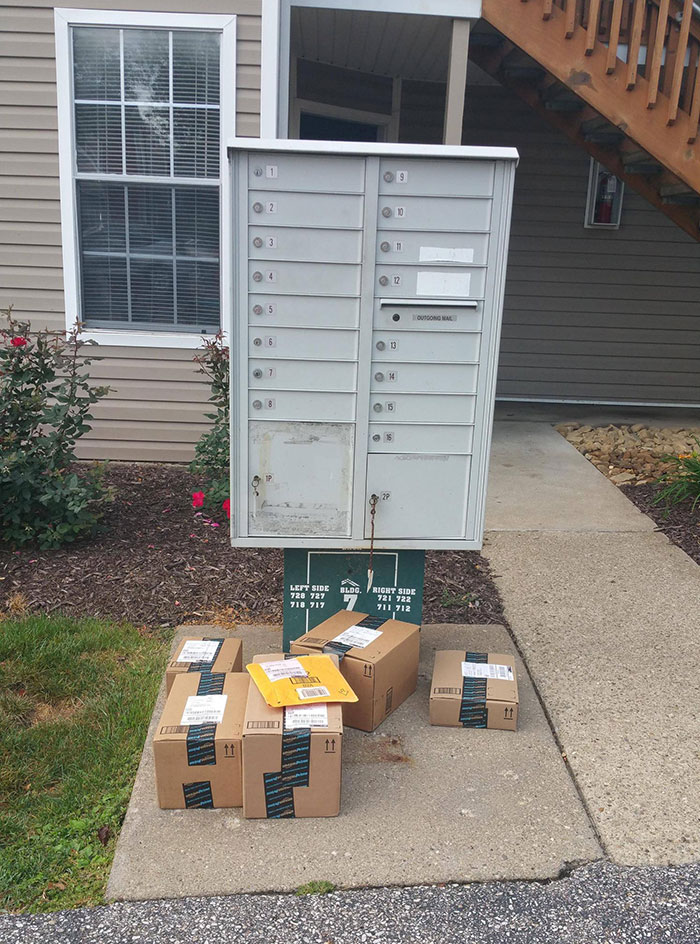 A cluster of packages outside a mailbox, illustrating extreme laziness in delivery placement.