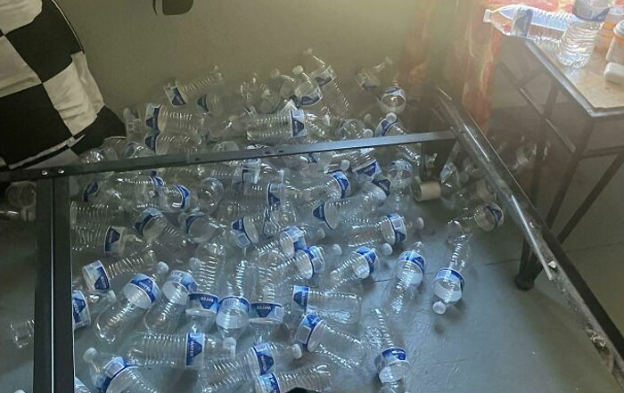 Empty plastic water bottles scattered under a bed, epitomizing lazy habits.