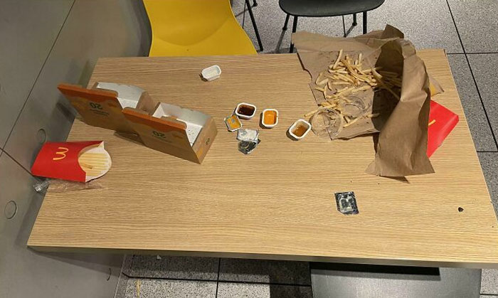 Fast food trash left on a table, illustrating lazy infuriating people behavior in public spaces.