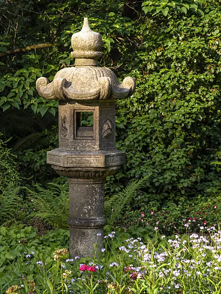 427088 - Large stone lantern with curved stone roof in a garden