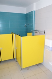 Yellow bathroom stalls with blue and white tiled walls