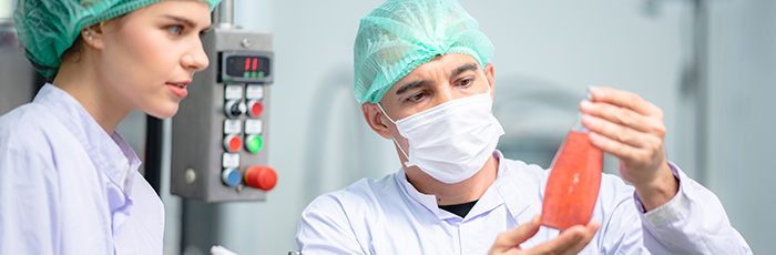 Food technicians checking drink product in bottle