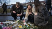 People light candles at a makeshift vigil near the adult education center Campus Risbergska school in Örebro, Sweden, on Feb. 5, 2025, one day after a shooting there left 11 people dead.