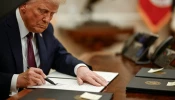 President Donald Trump signs executive orders in the Oval Office of the White House.