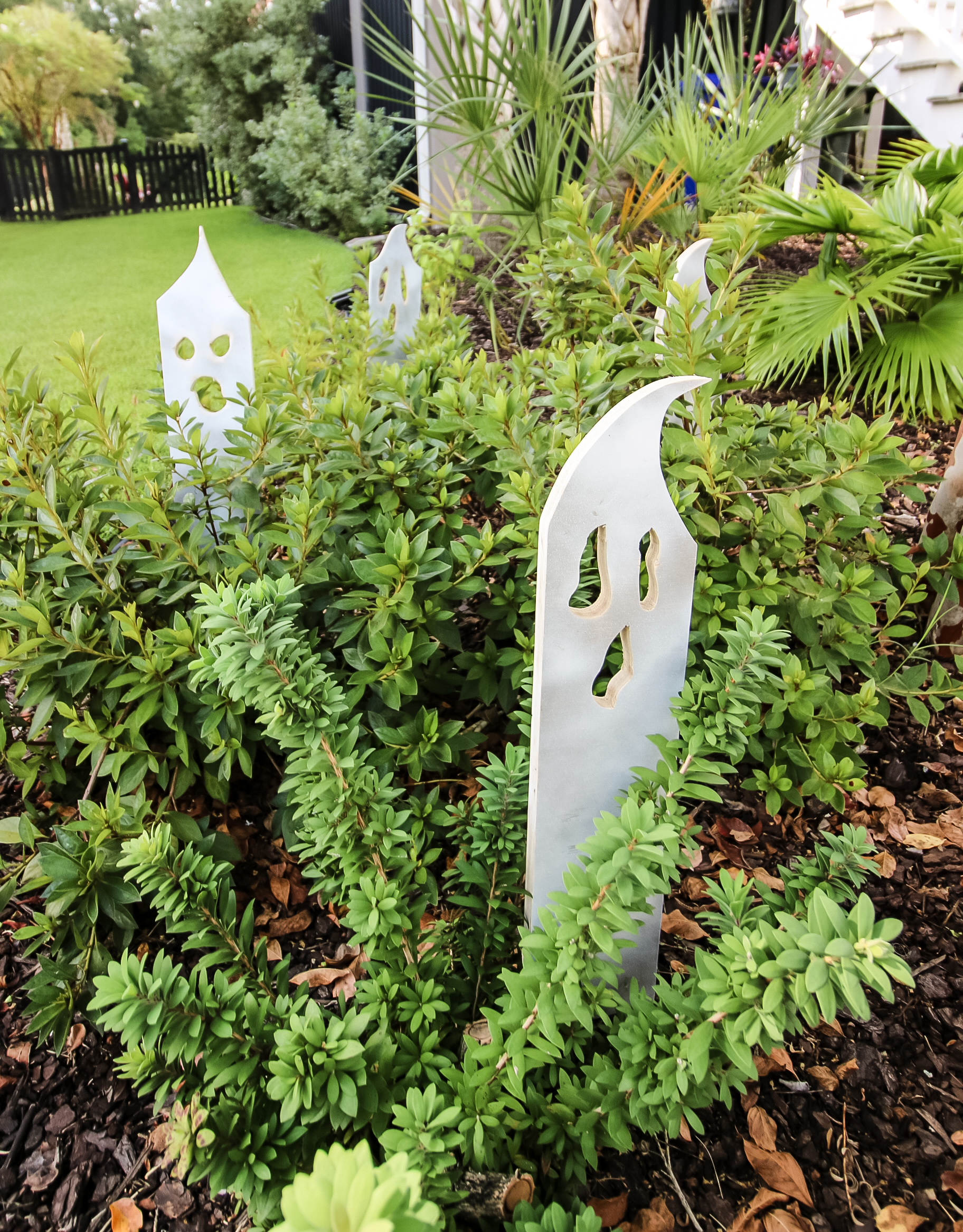 Wooden ghosts in bushes