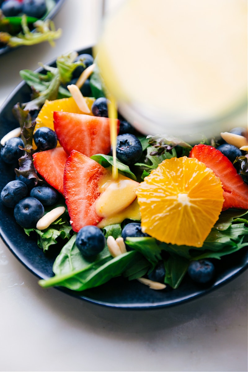 Image of the Citrus Vinaigrette being poured over a salad