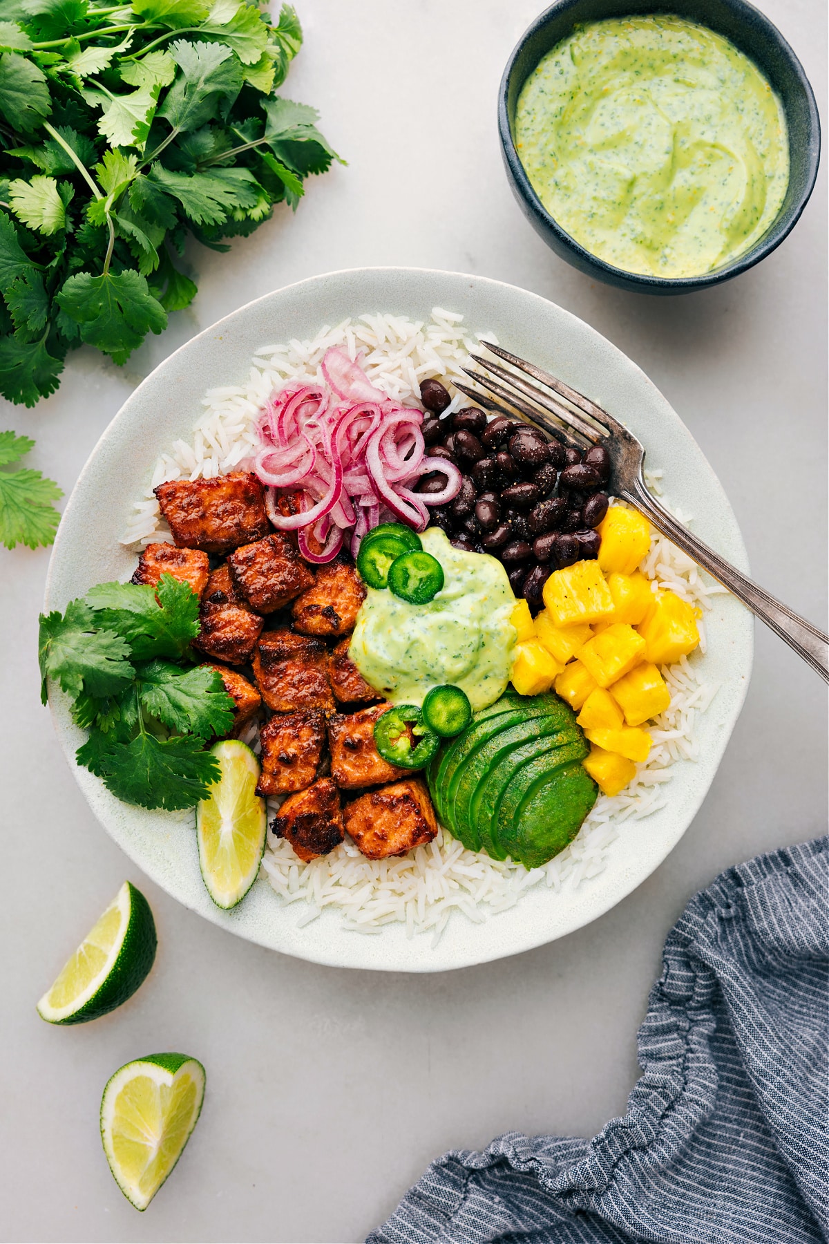 Mojo Salmon Bowls with all the toppings and dressing ready to be enjoyed.