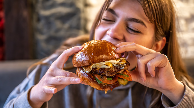 Girl eating a giant hamburger