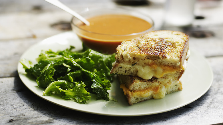 Sandwich, soup, and salad on white plate