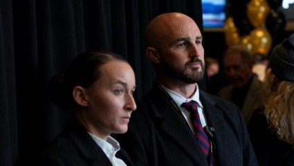 Army CID Protective Service Agents, one female and one male, watching a crowd of people