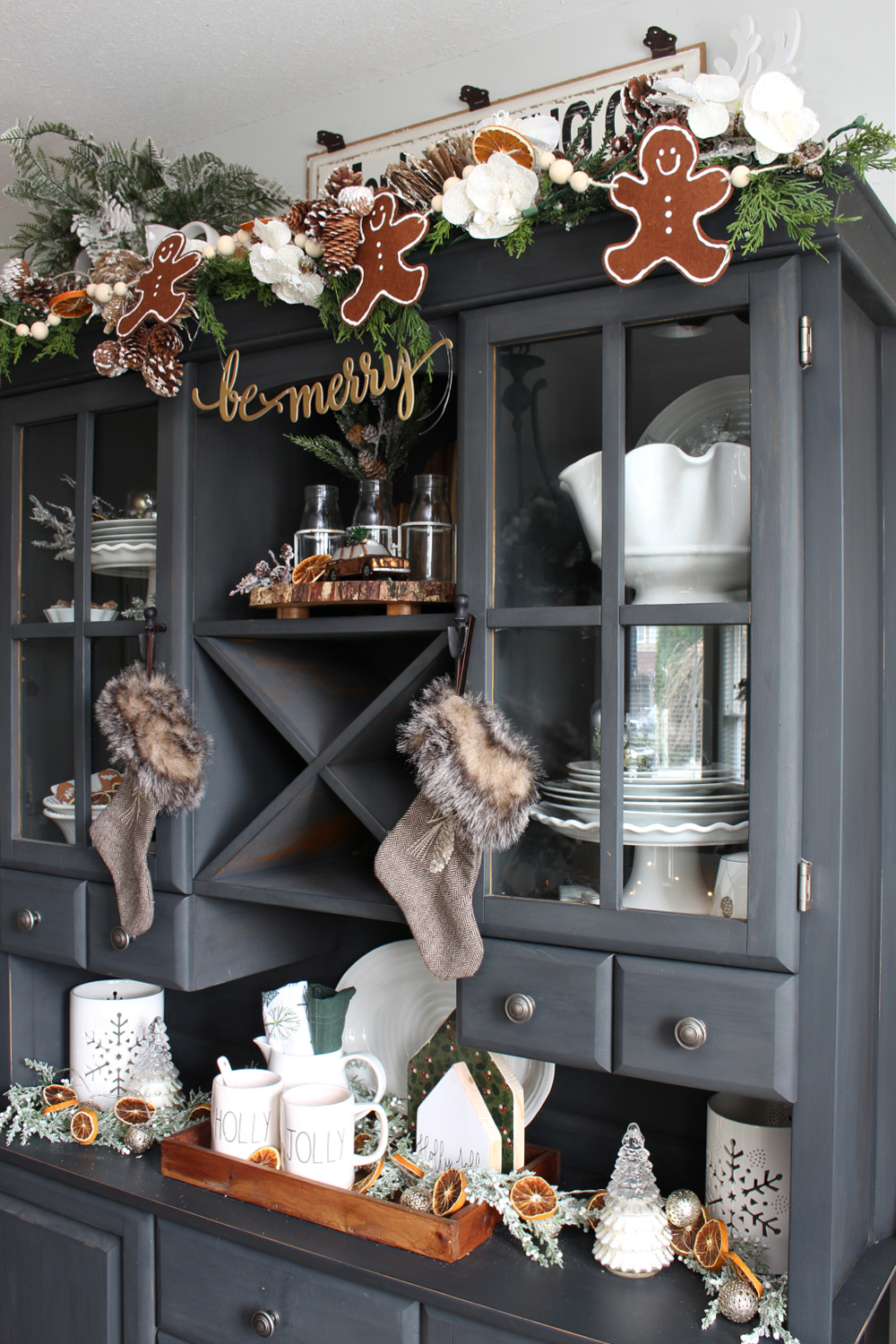 DIY felt gingerbread man garland on a Christmas hutch.