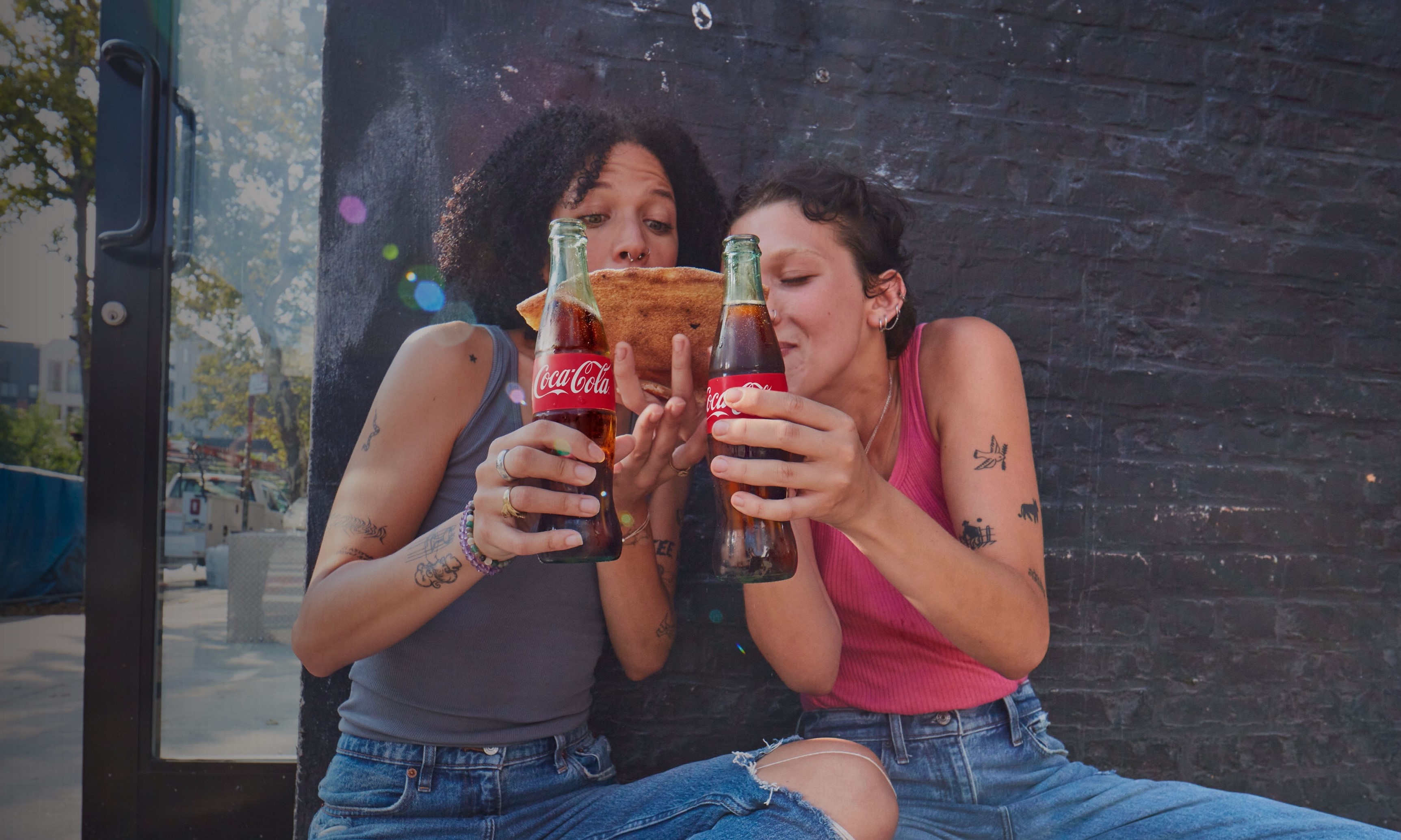 Two women holding bottles of Coca-Cola