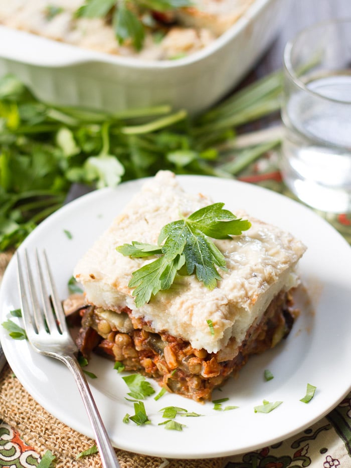 Table Set with Baking Dish, Water Glass, and Plate of Vegan Eggplant Moussaka