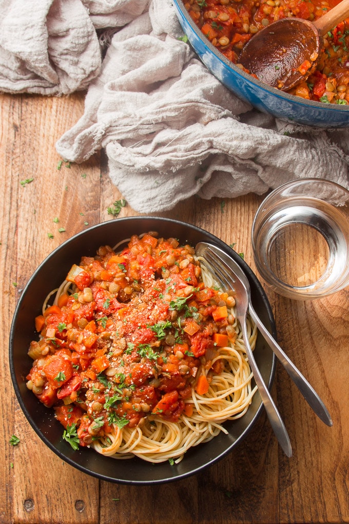 Table Set with a Large Pot, Plate of Pasta and Lentil Bolognese, and Water Glass