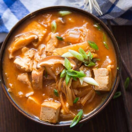 Bowl of Vegan Kimchi Stew with chopped scallions on top.