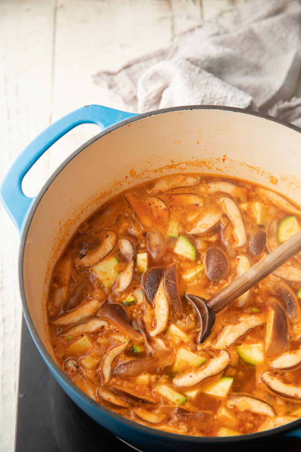 Shiitake mushrooms and zucchini simmering in broth.