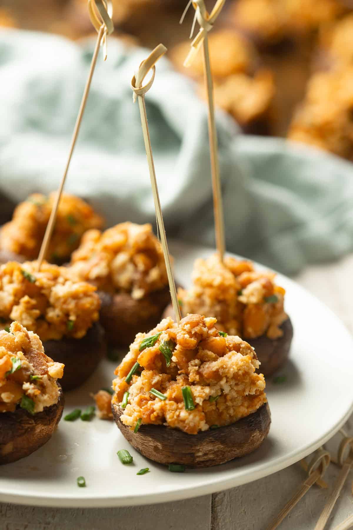 Vegan Stuffed Mushrooms on a dish with a blue napkin in the background.